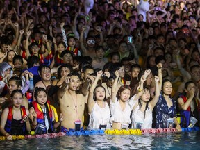 This file photo taken on Aug. 15, 2020, shows people watching a performance as they cool off in a swimming pool in Wuhan in China's central Hubei province. The massive pool party attended by thousands of people at the epicentre of the COVID-19 coronavirus pandemic showed how well China had dealt with disease, authorities insisted on Aug. 20, 2020, despite images from the event prompting outrage around the world.