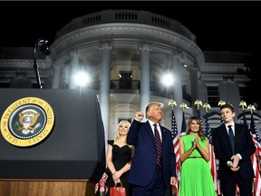 First Lady Melania Trump (2nd R), Barron Trump (R) and Tiffany Trump stand with US President Donald Trump as he pumps his fist after he delivered his acceptance speech for the Republican Party nomination for reelection during the final day of the Republican National Convention at the South Lawn of the White House in Washington, DC on August 27, 2020.