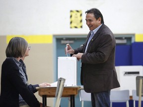 Assembly of First Nations National Chief Perry Bellegarde, right, casts his vote in the 2015 federal election at the Hopewell Avenue Public School polling station in Ottawa on October 19, 2015.