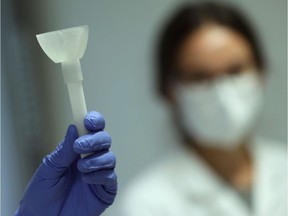 A laboratory worker shows a prototype of a self-test that will use saliva in a rapid COVID-19 test, which could replace more commonly used swabs, at the University of Liege, Belgium August 12, 2020. According to the university, the test allows thousands of additional tests to be performed every day.