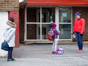 Students line up to have their hands sanitized in the schoolyard in Saint-Jean-sur-Richelieu on May 11.