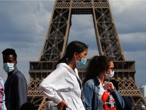 People wearing protective face masks walk at the Trocadero square near the Eiffel Tower in Paris as France reinforces mask-wearing as part of efforts to curb a resurgence of the coronavirus disease (COVID-19) across the country, August 3, 2020. REUTERS/Gonzalo Fuentes