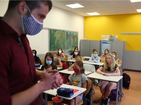 Schoolgirls and schoolboys of the fifth year voluntarily wear protective face masks inside their classroom as schools re-open after summer holidays and the lockdown due to the outbreak of the coronavirus disease (COVID-19) at the Karl-Rehbein high school in Hanau, Germany, August 17, 2020.   REUTERS/Kai Pfaffenbach