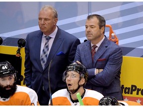 Philadelphia Flyers head coach Alain Vigneault (right) and assistant Michel Therrien look on from behind team bench during third period of 5-0 loss to the Canadiens in Game 2 of their playoff series Friday afternoon at Toronto’s Scotiabank Arena.