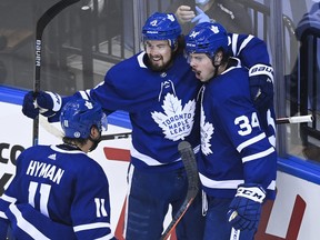 Maple Leafs centre Auston Matthews (34) celebrates his goal with teammates Justin Holl (3) and Zach Hyman after scoring against the Columbus Blue Jackets in the second period of their NHL Eastern Conference play-in game on Tuesday.
