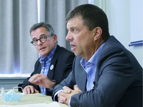 Michel Murray, left, of the Canadian Union of Public Employees, listens to Martin Tessier of the Maritime Employers Association, during a joint news conference in Montreal on Friday, Aug. 21, 2020.