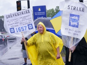 Striking Port of Montreal workers brave the elements to walk the picket line in Montreal on Monday, August 17, 2020. The workers have been without a contract for over two years.