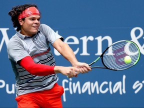 Milos Raonic returns a shot to Stefanos Tsitsipas in their semifinal match during the Western and Southern Open at the USTA Billie Jean King National Tennis Center on Friday, Aug. 28, 2020, in New York.