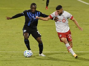 Montreal Impact defender Zachary Brault-Guillard (15) plays the ball and Toronto FC midfielder Jonathan Osorio (21) defends during the first half at Stade Saputo.