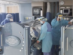 In this April 2020 photo provided by The Wound Treatment Center, two COVID-19 patients are treated in hyperbaric chambers at a hospital in Opelousas, La. The therapy involves delivering 100% oxygen straight to patients inside a pressurized chamber.