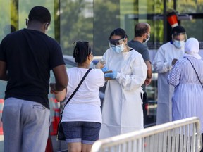 People are screened while in line at the COVID-19 testing centre at the Gerry-Robertson Community Centre in Pierrefonds on Aug. 6, 2020.