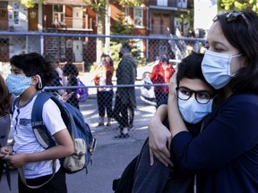 A mom says goodbye to her son on his first day of classes at Bancroft Elementary School in Montreal Aug. 31, 2020.