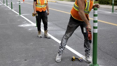 City workers install bollards as the Terrebonne St. bike path is extended to Cavendish St. on Tuesday, Sept. 1, 2020.