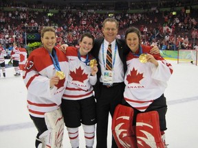 Peter Smith, assistant coach of the 2010 Canadian Olympic team, poseg with McGill players Kim St-Pierre, left, Catherine Ward and  Charline Labonte after winning gold at the Vancouver Olympics.