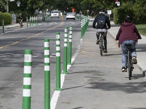 Cyclists and cars take notice of the newly installed bollards on the Terrebonne St. bike path near Cavendish Blvd. on Friday Sept. 4, 2020.