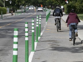 Cyclists and cars take notice of the newly installed bollards on a bike path on Terrebonne St. near Cavendish Blvd. on Friday Sept. 4, 2020.