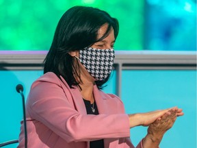 Montreal Mayor Valérie Plante puts on her mask and sanitizes her hands at the end of Tuesday's launch of the Relançons MTL initiative at the Palais des congrès.