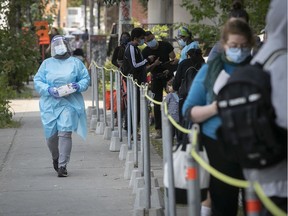 A nurse walks near people waiting for COVID-19 testing at CLSC Parc-Extension on Wednesday September 16, 2020.