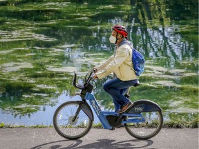 A man wearing a mask rides an electric Bixi next to the pond in Parc Lafontaine in Montreal in September 2020. Bixi will offer a seasonal subscription for the 2021 season.
