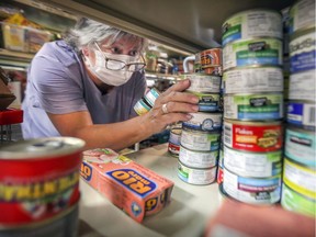 Volunteer Gisella Solari stacks canned goods on shelves at On Rock Community Services in Pierrefonds.