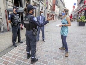 Montreal police Constables Giuseppe D'Ignazio, Marie-Pierre Gobeil and Detective Frantz Jean-Louis speak with Sara Theberge outside her Artisans Canada boutique on St-Paul St. in Old Montreal on Thursday.