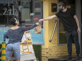 Hubert Hotte brings out food for waiting customer picking up an order at a restaurant on Rachel St. on Sept. 28, 2020.