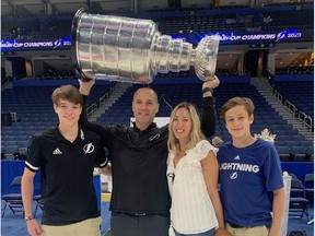 Tampa Bay Lightning director of hockey operations Mathieu Darche hoists the Stanley Cup alongside, from left, son Samuel, 17, wife Stéphanie and son Benjamin, 15, after the Lightning won the Cup at Rogers Place in Edmonton.