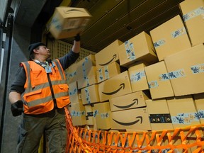 A worker loads a truck with packages at an Amazon packaging center on November 28, 2019 in Brieselang, Germany.