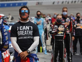 Bubba Wallace, driver of the #43 McDonald's Chevrolet,  wears  a "I Can't Breath - Black Lives Matter" T-shirt under his fire suit in solidarity with protesters around the world taking to the streets after the death of George Floyd on May 25 while in the custody of Minneapolis, Minnesota police, stands during the national anthem prior to the NASCAR Cup Series Folds of Honor QuikTrip 500 at Atlanta Motor Speedway on June 07, 2020 in Hampton, Georgia.