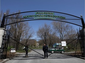 An employee is seen the gate of the Notre-Dame-des-Neiges cemetery in Montreal, on Tuesday, May 12, 2020.