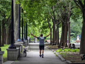 A man does arm exercises while walking his dog in Parc Lafontaine in Montreal on Wednesday, September 2, 2020. (John Mahoney / MONTREAL GAZETTE)