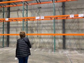 A woman looks at empty paper product shelves at a Costco store in Pointe Claire on Sept. 23, 2020.
