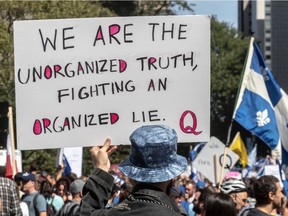 Supporters of the QAnon conspiracy theory march with anti-mask protesters at a march in Montreal on Saturday, Sept. 12, 2020.