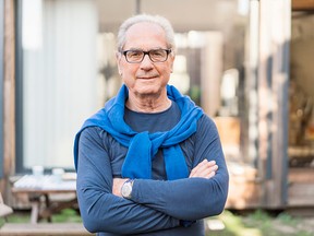 Confident senior man with arms crossed in backyard