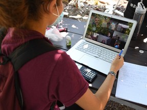 A student in California takes an online class while sitting in a community garden.