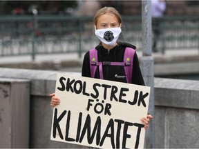 Swedish climate activist Greta Thunberg holds a poster reading "School strike for Climate" as she protests in front of the Swedish Parliament Riksdagen on Sept. 4, 2020.
