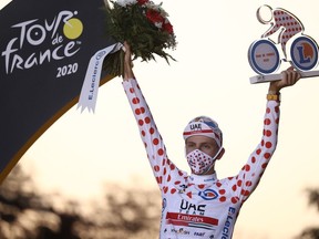 Team UAE Emirates rider Slovenia's Tadej Pogacar celebrates on the podium after winning the best climber's polka dot jersey of the 107th edition of the Tour de France cycling race, after the 21st and last stage of 122 kilometres between Mantes-la-Jolie and Champs- Élysées in Paris, on Sunday, Sept. 20, 2020.