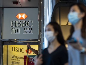 Pedestrians wearing protective masks walk past a HSBC Holdings Plc branch in Hong Kong on Sept. 21, 2020.