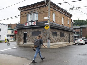 A man walks by the Bar Kirouac, which was closed after people were infected with COVID-19 while participating in karaoke earlier in the week, Wednesday, September 2, 2020 in Quebec City.