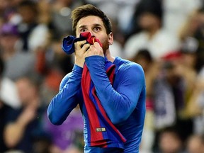 In this file photo taken on April 23, 2017, Barcelona's Lionel Messi kisses his jersey after brandishing it to celebrate his goal at the Santiago Bernabeu stadium in Madrid.