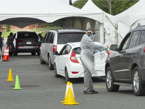 People wait to get tested at a drive-thru COVID-19 clinic Wednesday, Sept. 16, 2020 in Longueuil.