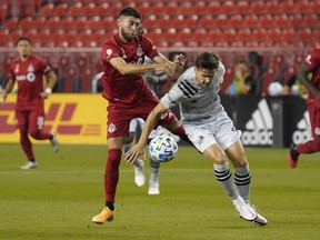 Toronto FC midfielder Jonathan Osorio (21) and Montreal Impact defender Jukka Raitala (22) battle for the ball during the first half at BMO Field on Tuesday.