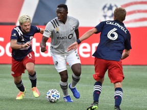 Impact midfielder Victor Wanyama keeps the ball away from Revolution midfielders Kelyn Rowe and Scott Caldwell at Gillette Stadium on Wednesday, Sept. 23, 2020.