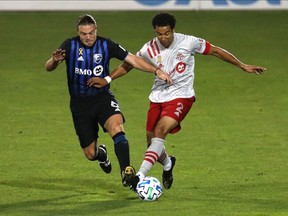 Impact midfielder Samuel Piette and Toronto FC defender Justin Morrow battle for the ball during the second half at Stade Saputo on Wednesday night. Toronto won 2-1.