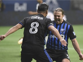 Impact midfielder Samuel Piette celebrates his goal with midfielder Saphir Taïder after scoring against the Whitecaps goalkeeper Sunday night at B.C. Place.