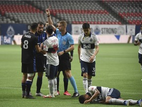 Montreal Impact defender Rudy Camacho receives a red card after an altercation with Vancouver Whitecaps forward Fredy Montero, lying on the pitch, during the first half at BC Place on Sept. 16, 2020.