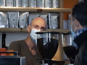 Remy Deloume wears his face mask as he takes a client's order at Café L'Étincelle in Montreal, on Oct. 6, 2020.
