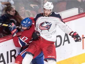 Montreal Canadiens defenseman Brett Kulak (17) is checked along the boards by Columbus Blue Jackets right wing Josh Anderson (77) during 2nd period NHL action at the Bell Centre in Montreal, on Tuesday, February 19, 2019.