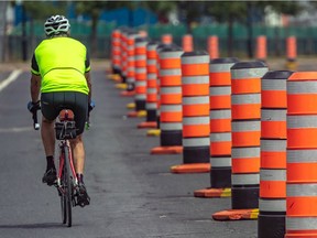 A cyclist rides past cones on June 26, 2020.