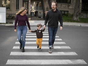 Dylan Jervis, wife Allana and son Shea cross St-Joseph at Hutchinson. This is where an SUV rolled over Shea last year, causing severe internal injuries.